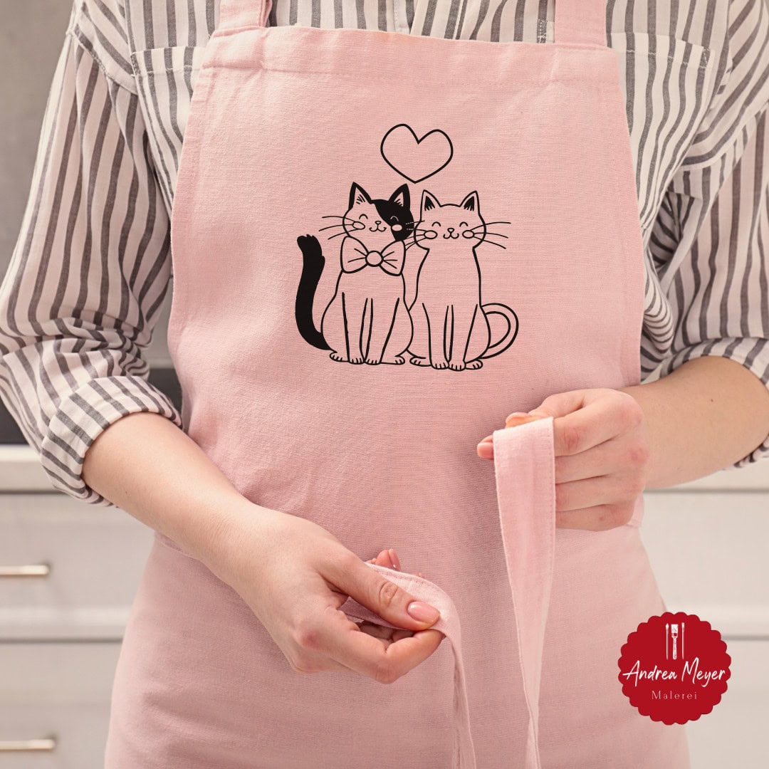 Valentinstag zum Selbermachen: Kreative Plotterideen mit tierischen Motiven 4 Zwei Katzen Illustration auf Kochschürze, Katzenkunst, Dekorative Malerei, Andrea Meyer Malerei, Katzen Design Kunst, Smile Display, Junge Frau in Küche, Kreative Tierkunst, Handgemalte Tiermotive, Liebevolle Tierillustration.