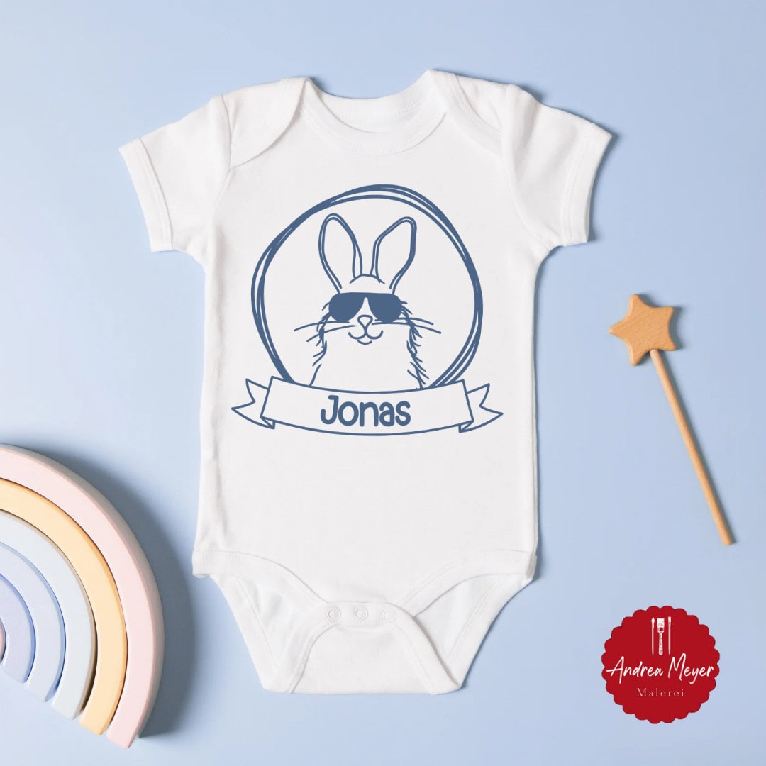 Geschenke zur Geburt plotten – Kreative DIY-Ideen mit personalisierten Plotterdateien 11 Süßer Hase mit Sonnenbrille und dem Namen deines Kindes auf einem Baby Strampler - Geschenke zur Geburt plotten - Kreative DIY Ideen mit personalisierten Plotter Dateien für Cricut und Silhouette.
